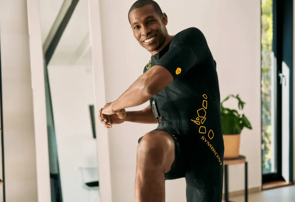 A man in an EMS suit trains in the studio, engaging in an effective and intense workout to reduce fat and support weight loss with EMS.